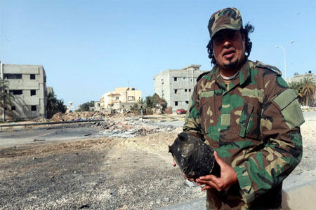 Senior army Special Forces commander Fadel al-Hassi points at the site of an explosion in Benghazi Feb. 6, 2015. (Reuters)