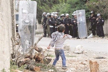طفل فلسطيني يواجه جنود الاحتلال في قرية كفر قدوم قرب نابلس في الضفة الغربية المحتلة أمس