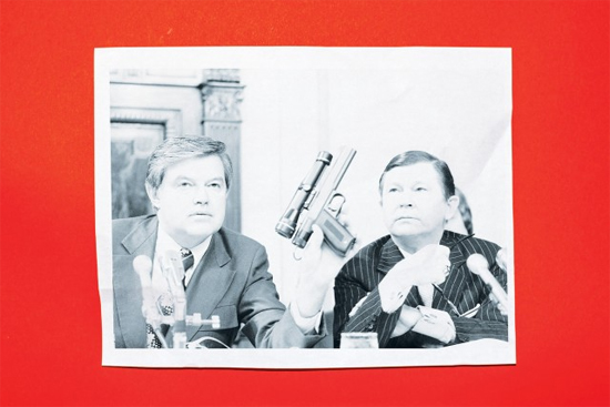  (السناتور فرانك جرج يحمل مسدس سام، والسناتور جون تاور ينظر إلى هذا السلاح، أثناء مؤتمر لوكالة المخابرات المركزية في سبتمبر 1975)
