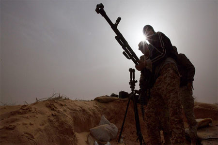 In this Saturday, Feb. 21, 2015 photo, Libyan soldiers try to fix a weapon that jammed during clashes with militants on the frontline in Al Ajaylat, 120 kilometers (75 miles) west of Tripoli, Libya. (AP)