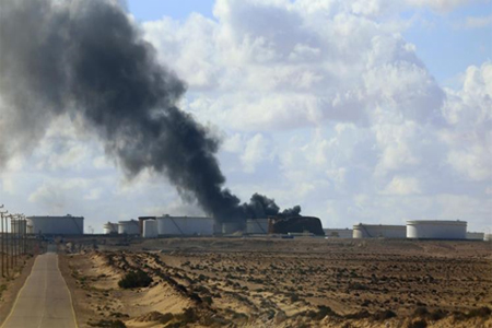 مخازن للنفط يتصاعد منها الدخان الأسود نتيجة تعرضها لهجوم قرب ميناء السدر نهاية العام الماضي (رويترز)